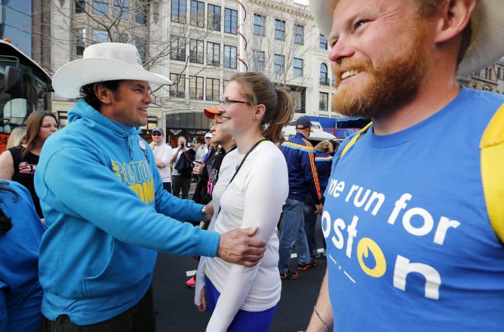 Carlos Arredondo, left, talks with Brittany Loring, center, before crossing the finish line of the Boston Marathon course as part of a cross country charity relay . Danny Bent, right, is one of the organizers of the race. (Michael Dwyer/AP)