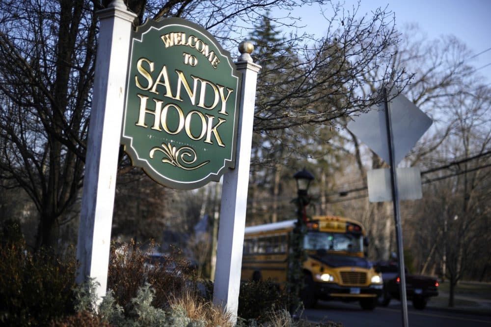 A bus drives past a sign reading Welcome to Sandy Hook Dec. 4, 2013, in Newtown, Conn. (Jessica Hill/AP)