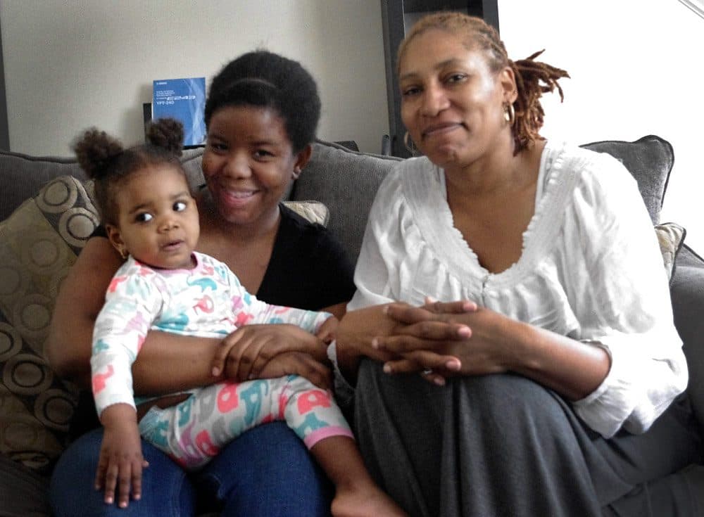 Patricia Wornum (right) is a 'home visitor' with Healthy Families. Every two weeks she check in with Keisha Harrison and her daughter, Cassidy, in their Dorchester home (Gabrielle Emanuel/WBUR)