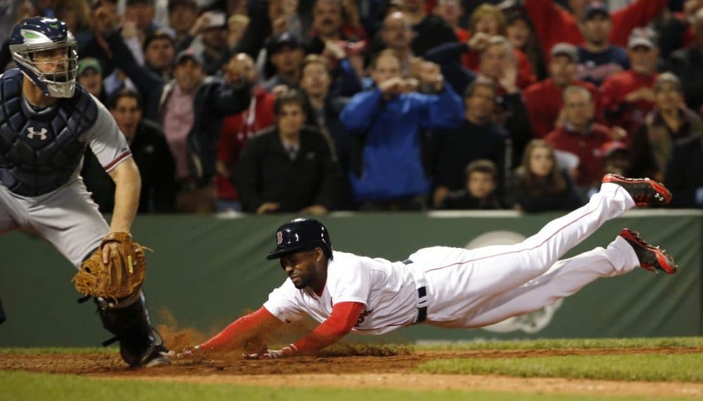 Boston Red Sox's Jackie Bradley Jr. dives home with the game-winning run on an infield single by teammate Xander Bogaerts as catcher Evan Gattis, left, looks on during the ninth inning. (AP/Winslow Townson)