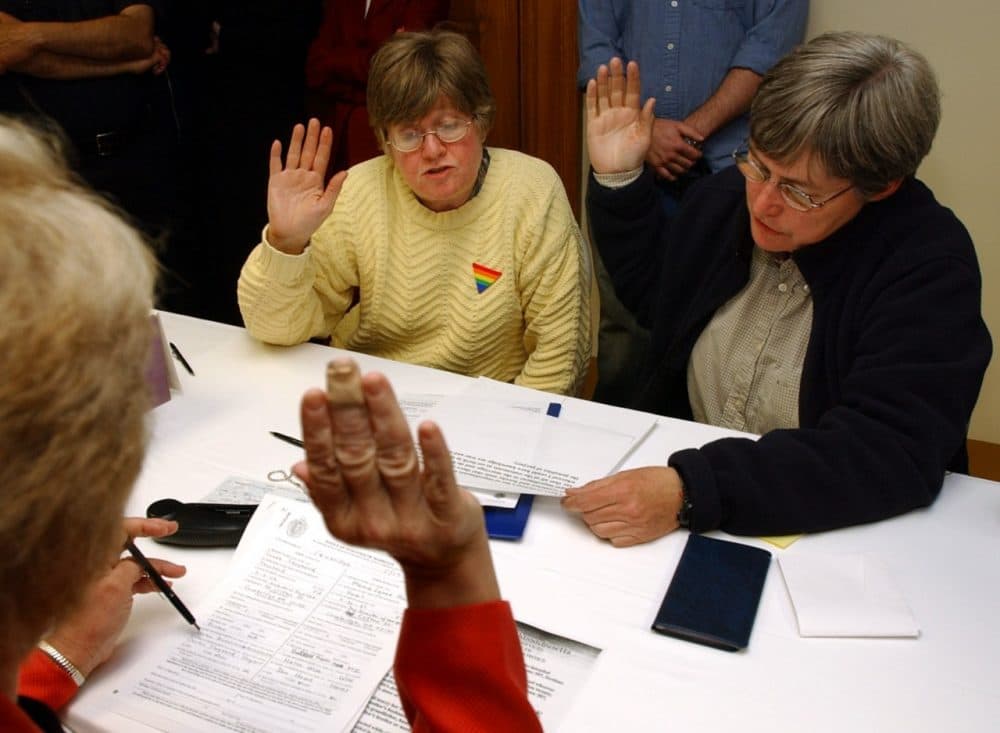 Marcia Hams, center, and her partner Susan Shepherd, right, both of Cambridge, Mass., raise their hands to take an oath administered by City Clerk D. Margaret Drury, left, at Cambridge City Hall, in Cambridge, as they participate in the application process for a marriage license several minutes after midnight Monday, May 17, 2004. Hams and Shepherd were the first couple to begin the application process as Massachusetts became the first state to legalize same-sex unions in the United States. (AP)