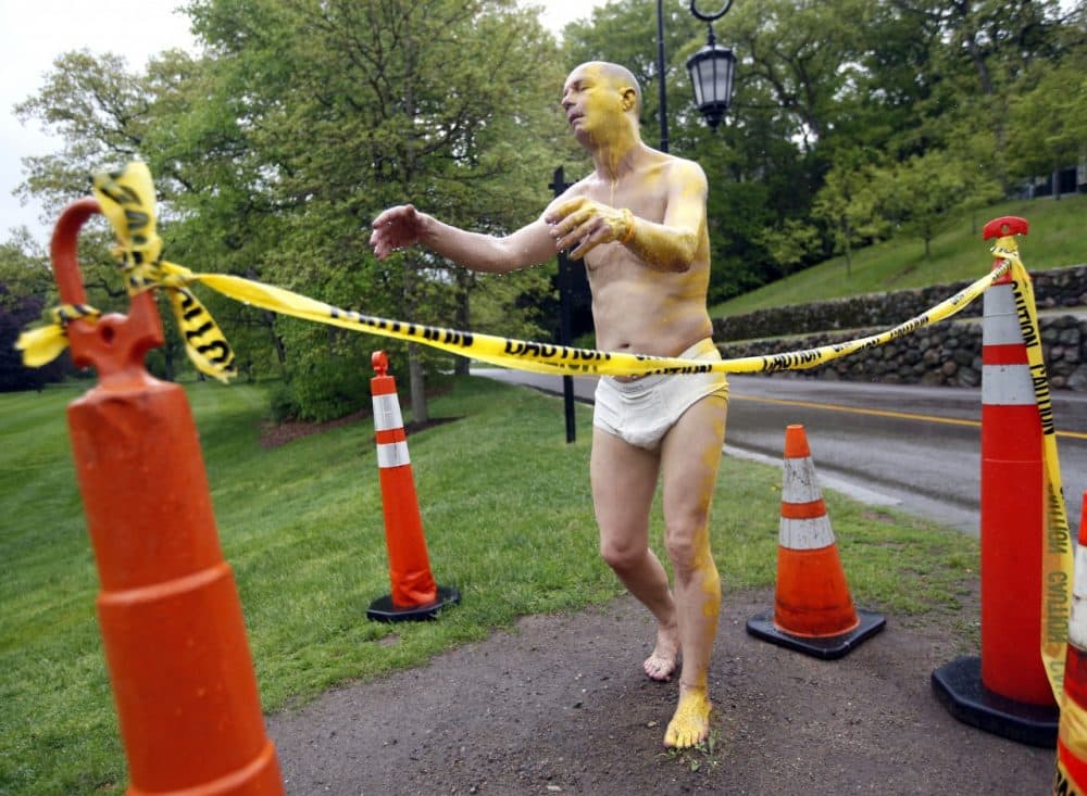 A fiberglass sculpture at Wellesley College, entitled &quot;Sleepwalker,&quot; is surrounded by cones and yellow caution tape, Wednesday, May 22, 2014, after being defaced Tuesday night with yellow paint on its face, left arm, left leg, and a foot. It was one of several properties on campus vandalized, and campus police are investigating. The outdoor, lifelike sculpture of a man sleepwalking in his underpants had provoked some concern on the college campus in February. (AP)
