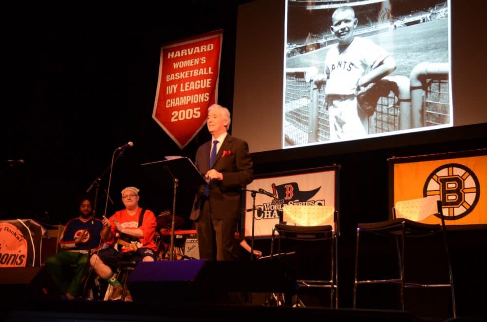 Scott Simon takes the stage at the Somerville Theatre with Bill's photo in the background. (Robin Lubbock/WBUR)
