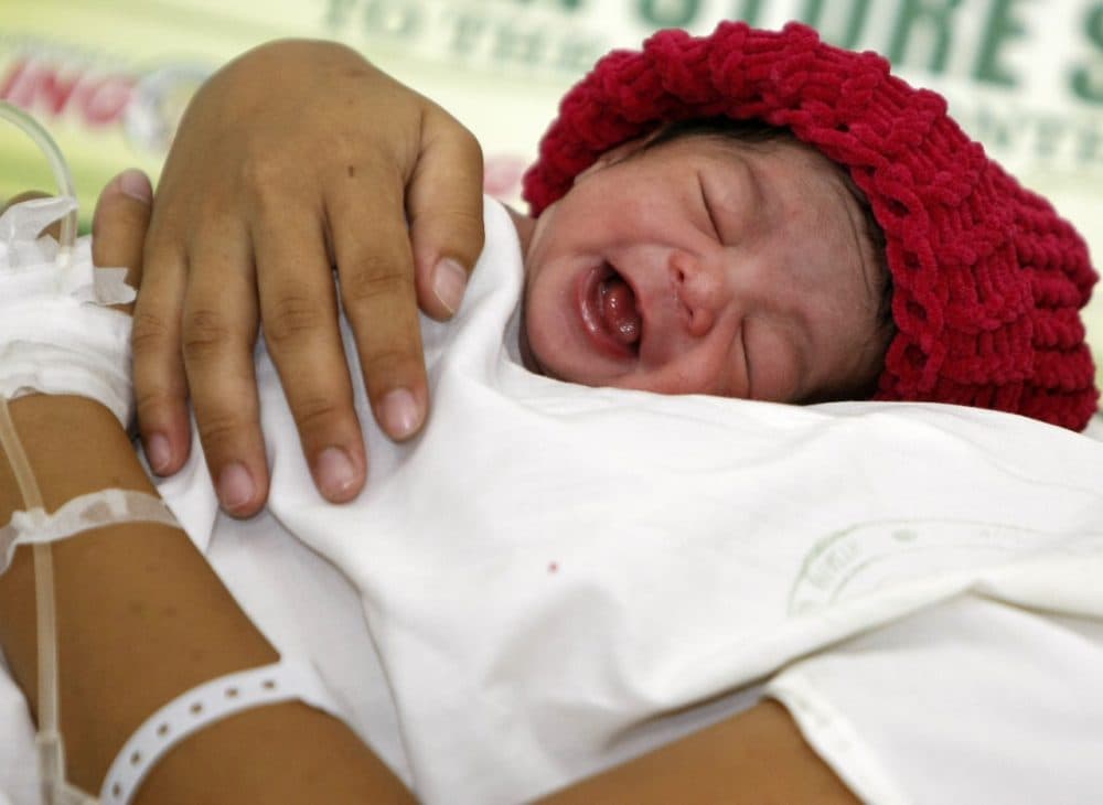 A newborn baby is cuddled by her mother. (Bullit Marquez/AP)