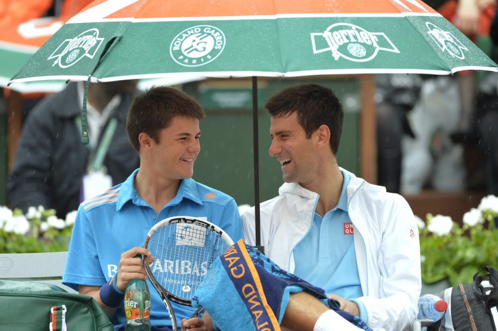  Novak Djokovic (right) shares a laugh with a ball boy during his French Open first round match. (Miguel Medina/AFP/Getty Images)