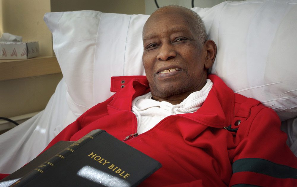 Kervin Elleyne, 67, receives end-of-life care at the Barbara McInnis House in Boston, which has 100 beds for homeless and undocumented individuals. He says it’s “one of the best places that a person could ever be.” (Gabrielle Emanuel/WBUR)