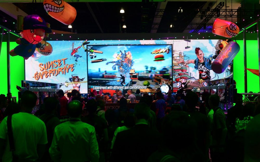 A crowd gathers around a big screen as gamers play Sunset Overdrive on Xbox at annual E3 video game extravaganza in Los Angeles, California on June 10, 2014. (Frederic J. Brown/AFP/Getty Images)
