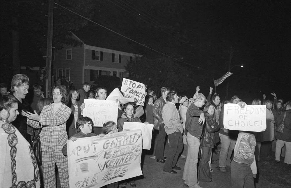 Demonstrators carrying signs gather the night of Oct. 5, 1974 outside the home of U.S. District Judge W. Arthur Garrity protesting the forced busing of Boston's schoolchildren. Judge Garrity ordered desegregation for Boston's schools (AP)