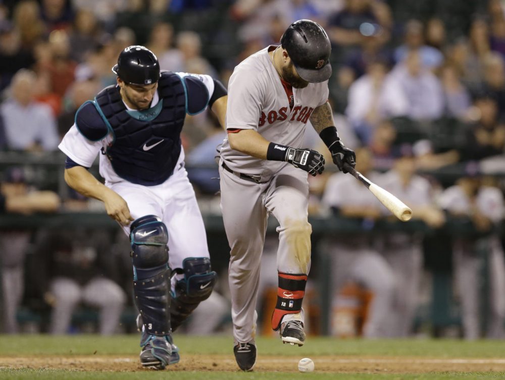 Mike Napoli steps over the ball as Mariners catcher Mike Zunino gives chase in the ninth inning of Tuesday's game in Seattle. Zunino made the play for the out. The Mariners won 8-2. (Elaine Thompson/AP)