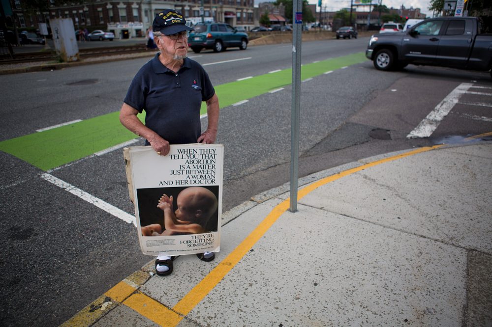 A protester stands outside the 35-foot buffer zone at a Planned Parenthood facility on Commonwealth Avenue in Boston on Thursday, after the Supreme Court struck down the state's buffer zone law. (Jesse Costa/WBUR)
