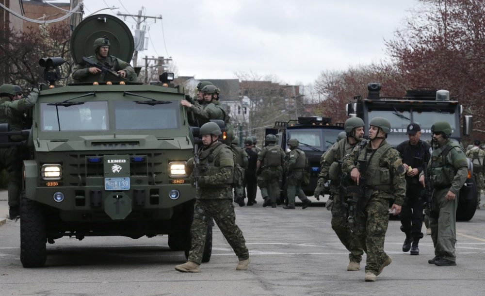 A SWAT team unloads from their armored vehicles as they go door to door while searching for a suspect in the Boston Marathon bombings in Watertown, Mass., Friday, April 19, 2013. (AP)