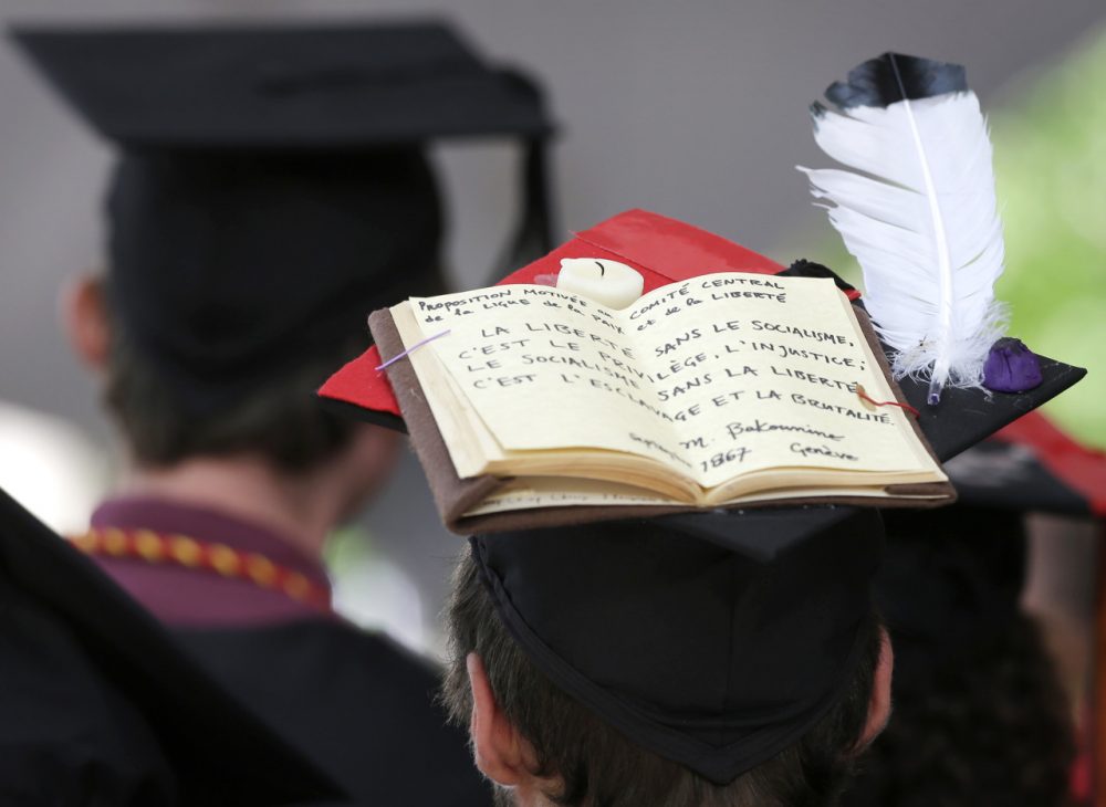 A graduating Harvard University student wears a mortar board that features a book and a feather during Harvard commencement ceremonies, Thursday, May 29, 2014, in Cambridge, Mass. (AP)