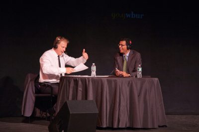On Point host Tom Ashbrook talks with Dr. Atul Gawande on the stage of the Paramount Theater in downtown Boston during the On Point LIVE event on June 12, 2014. (Judy West Photography)
