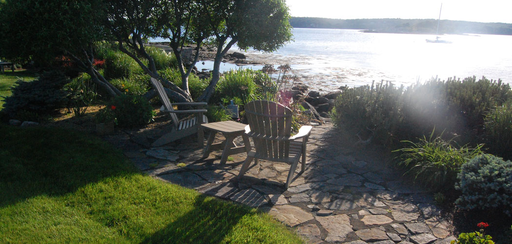 In this garden off Eastern Point Road in East Gloucester, the expansive lawn ends in patios situated under dwarf apple trees along the water’s edge. (Greg Cook)