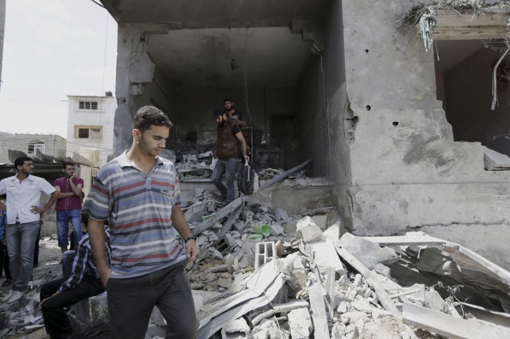 Palestinians look at the damaged house of Gaza's police chief Taysir al-Batsh after it was hit by an Israeli missile strike in Gaza City, Sunday, July 13, 2014. The strike that hit the home and damaged a nearby mosque as evening prayers ended Saturday, killed at least 18 people, wounded 50 and left some people believed to be trapped under the rubble, said Palestinian Health Ministry official Ashraf al-Kidra. (Adel Hana/AP)