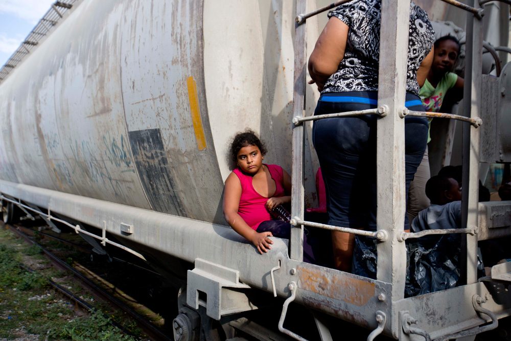 A young migrant girl waits for a freight train to depart on her way to the U.S. border in Ixtepec, Mexico, on July 12. (Eduardo Verdugo/AP)