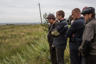 Men look at a body believed to be a passenger from the Air Malaysia flight MH17 on July 18 in Grabovka, Ukraine. (Brendan Hoffman/Getty Images)