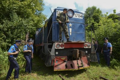 Police officers secure a refrigerated train loaded with bodies of the passengers of Malaysian Airlines flight MH17 as it arrives in a Kharkiv factory for a stop on Tuesday, July 22, 2014.(Olga Ivashchenko/AP)