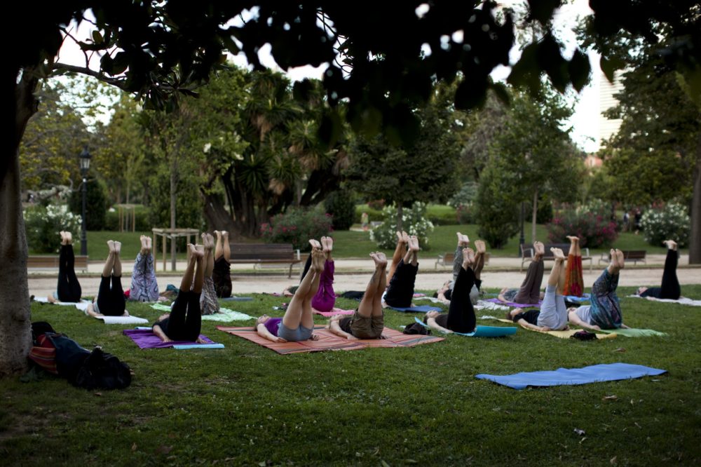 Men and women take part in an exercise class in a public park. (Emilio Morenatti/AP)