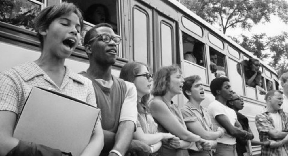 J. Kates: &quot;Fifty years later, the significance of 'Freedom Summer,' the Mississippi Voting Project of 1964, gets measured not by our accomplishments, but by our losses.&quot; Pictured: The author, fifth from left, and fellow volunteers sing beside their bus in Oxford, Ohio, in June 1964 before leaving for Mississippi to help blacks register to vote. (Ted Polumbaum/Newseum collection. Used by permission)