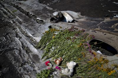 Toys and flowers are placed on the charred fuselage at the crash site of Malaysia Airlines Flight 17 near the village of Hrabove, eastern Ukraine, Sunday, July 20, 2014. (AP)