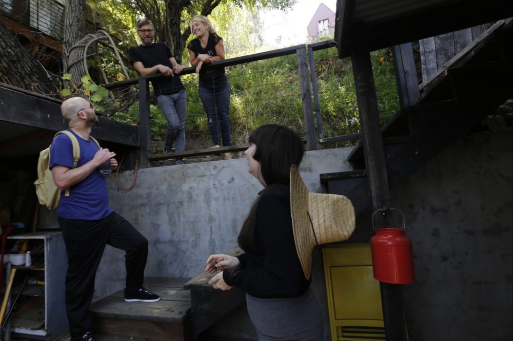 In this Monday, May 19, 2014 photo, ceramist and Airbnb host Jonathan Entler, top left, and his daughter Ruby, top right, talk to guests, James Green, bottom left, and Camille Smithwick from Manchester, U.K., at their Echo Park home in Los Angeles. (AP)
