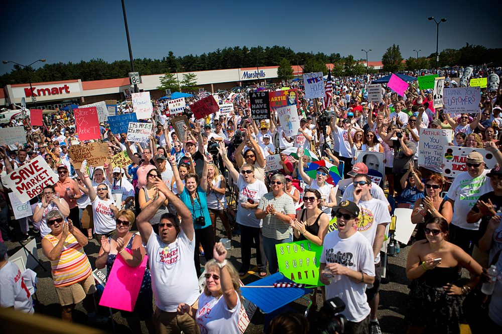 Though not mentioned by name, protesting Market Basket workers, like those seen here last month in Tewksbury, likely affected the state jobs figures.  (Jesse Costa/WBUR)