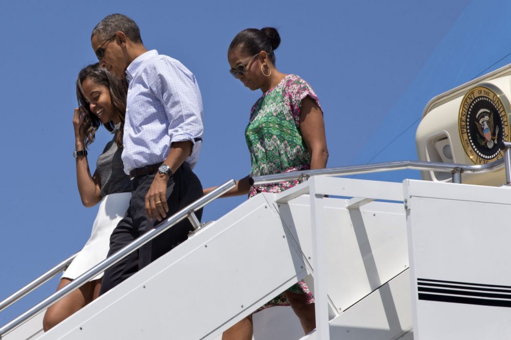 President Barack Obama walks with daughter Malia Obama and first lady Michelle Obama as they exit Air Force One at Cape Cod Coast Guard Air Station Saturday en route to Martha's Vineyard. (Jacquelyn Martin/AP)