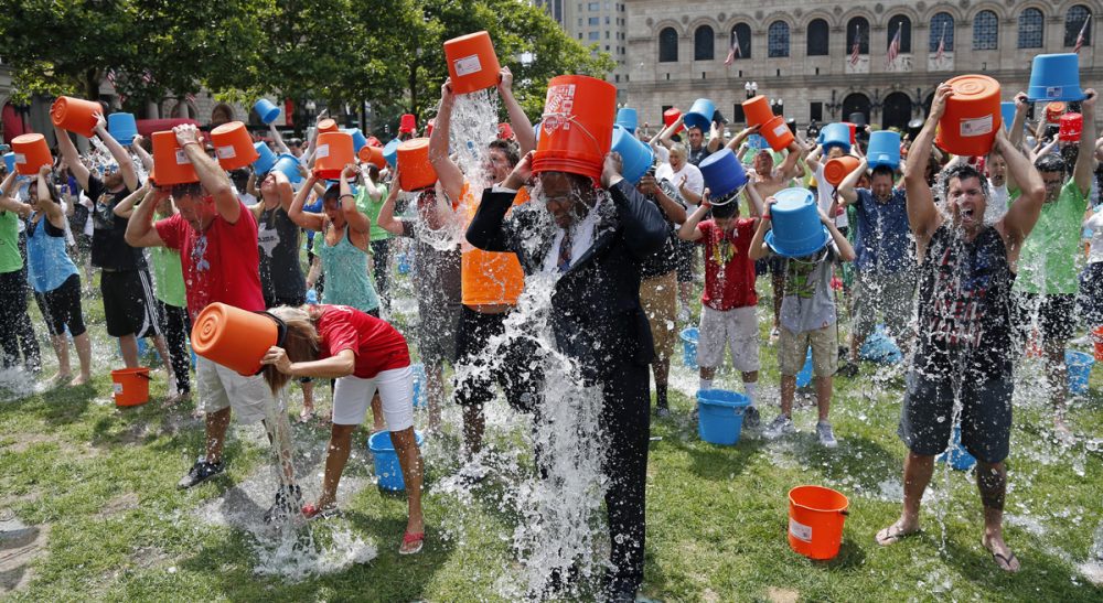 Is the Ice Bucket Challenge about raising awareness and money for a disease that has no cure, or it it just about showing off? Pictured: Boston City Councillor Tito Jackson, center, in suit, leads 200 people in the Ice Bucket Challenge at Boston's Copley Square, Thursday, Aug. 7, 2014. (Elise Amendola/AP)