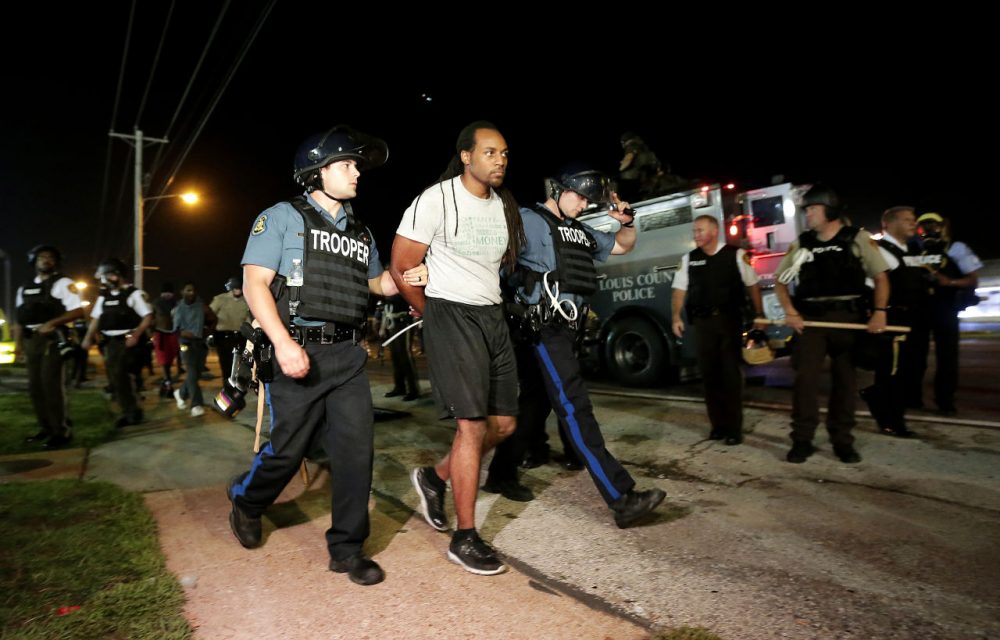 A man is lead away by police during a protest Monday in Ferguson, Mo. (Charlie Riedel/AP)