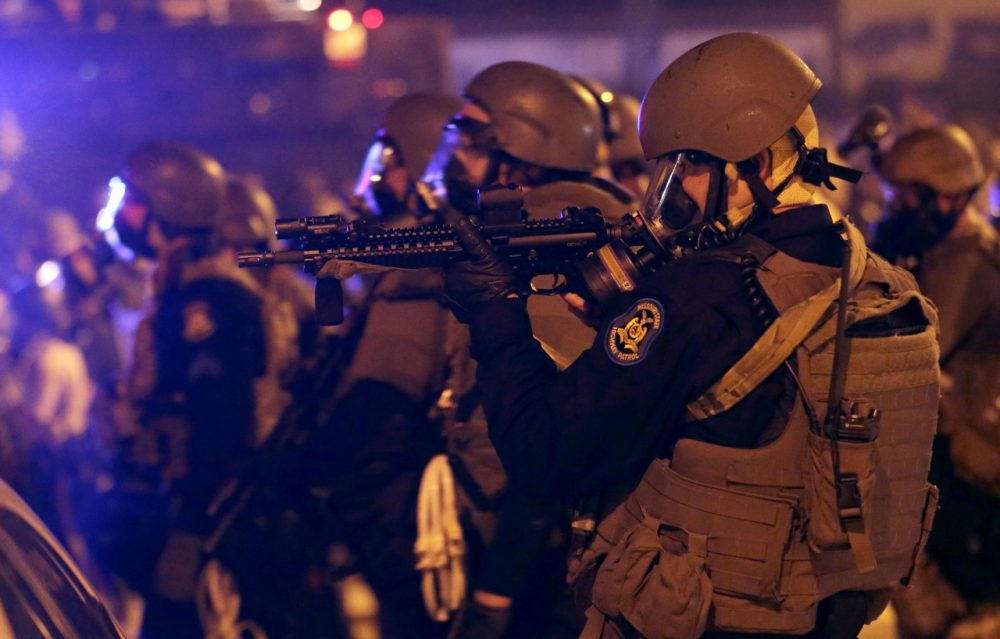 Police advance after tear gas was used to disperse a crowd Sunday, Aug. 17 during a protest for Michael Brown, who was killed by a police officer last Saturday in Ferguson, Mo. (Charlie Riedel/AP)