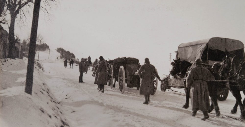 Truck, soldiers and horse-drawn artillery walking on a snow-covered road. (Margaret Hall/Courtesy of the Massachusetts Historical Society)