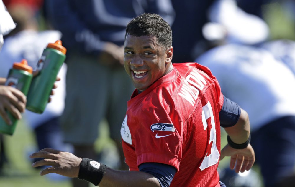 Russell Wilson and the Seattle Seahawks open the 2014 NFL season Thursday against the Green Bay Packers. (Elaine Thompson/AP Images)