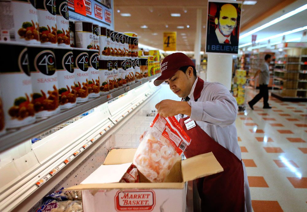 Market Basket employee Melbi Peraza, of Chelsea, restocks frozen shrimp at a Market Basket location in Chelsea Thursday. (Steven Senne/AP)