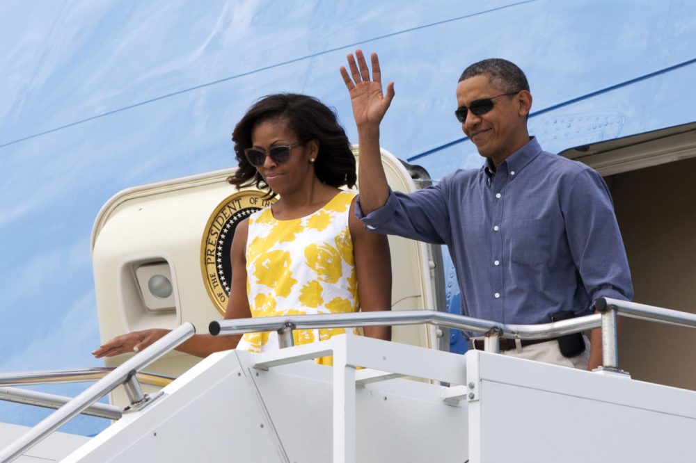 President Barack Obama and first lady Michelle Obama wave as they arrive in Cape Cod, Mass., to fly via helicopter to begin their family vacation in Martha's Vineyard in August 2013.  (Jacquelyn Martin/AP)