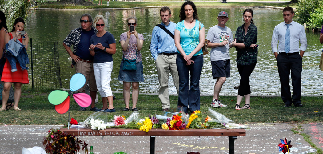 People pause by a bench at Boston's Public Garden Tuesday, where a small memorial has sprung up at the place where Robin Williams filmed a scene during the film &quot;Good Will Hunting.&quot; Williams, 63, died at his San Francisco Bay Area home Monday in an apparent suicide. (Elise Amendola/AP)
