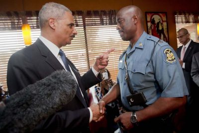 Attorney General Eric Holder talks with Capt. Ron Johnson of the Missouri State Highway Patrol at Drake's Place Restaurant, Wednesday, Aug. 20, 2014, in Florrissant, Mo. (AP)