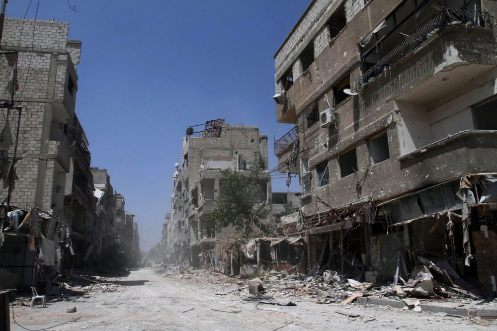 Buildings damaged during battles between Syrian troops and rebels stand along an empty street in Mleiha, some six miles southeast of downtown Damascus, Syria. (AP)