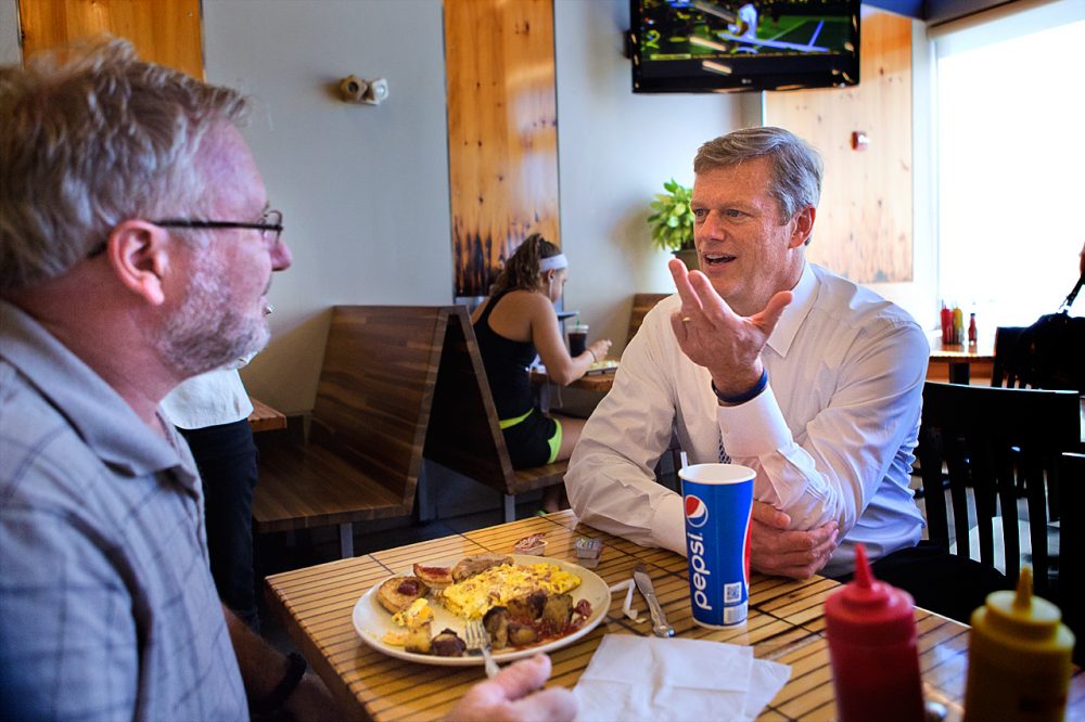 Republican gubernatorial candidate Charlie Baker, right, chats with Bradford Herrick, of Bridgewater, during a visit at Eagle’s Deli in Boston. (Jesse Costa/WBUR)