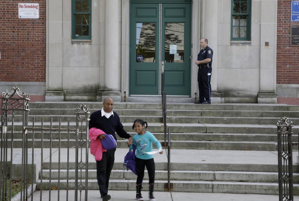 Gairy Bruce walks his daughter Shairy out of the gate at the Thomas J. Kenny Elementary School in Boston. (Stephan Savoia/AP)