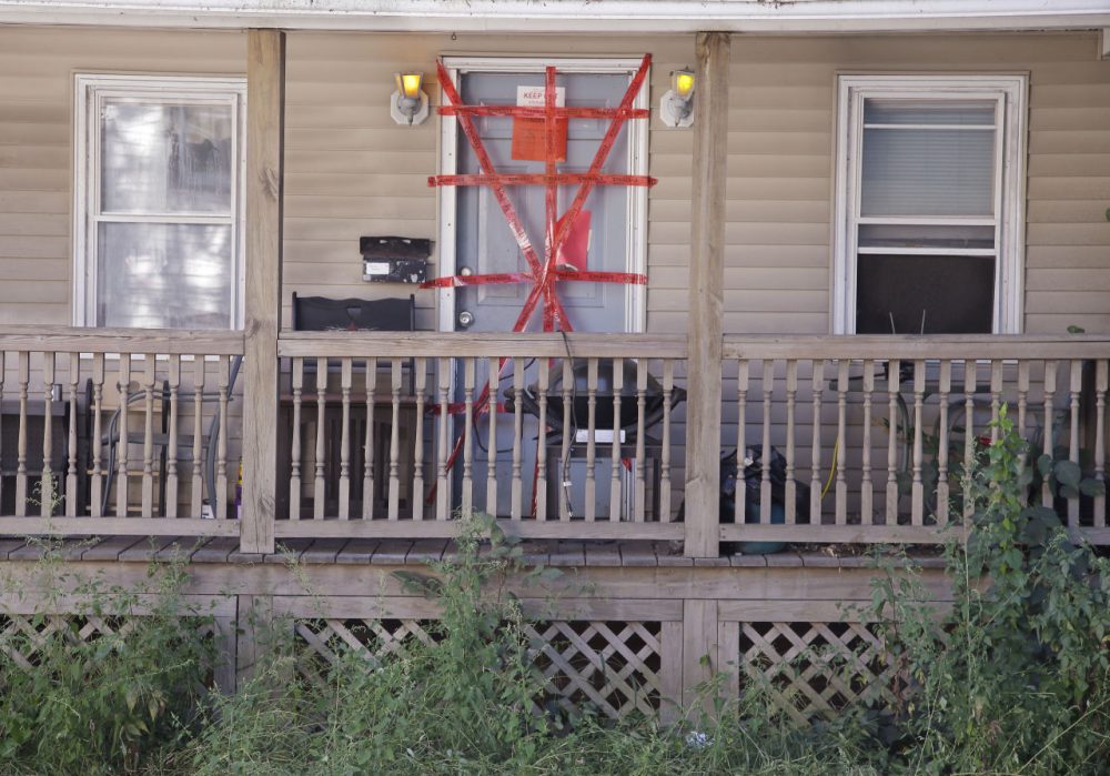 &quot;Condemned&quot; and &quot;keep out&quot; signs are attached behind police tape to the front door of a house where a Massachusetts prosecutor said the bodies of three infants were found Thursday in Blackstone, Mass.  (Stephan Savoia/AP)