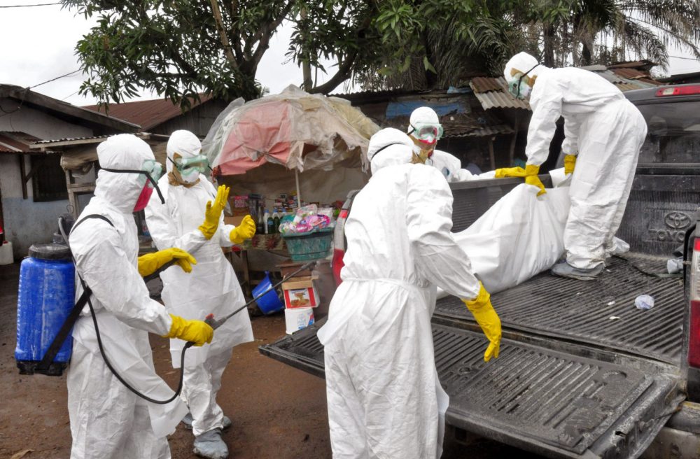 Health workers load the body of a woman they suspect died from the Ebola virus, onto a truck in front of a makeshift shop in an area known as Clara Town in Monrovia, Liberia, Wednesday, Sept. 10, 2014. (Abbas Dulleh/AP)
