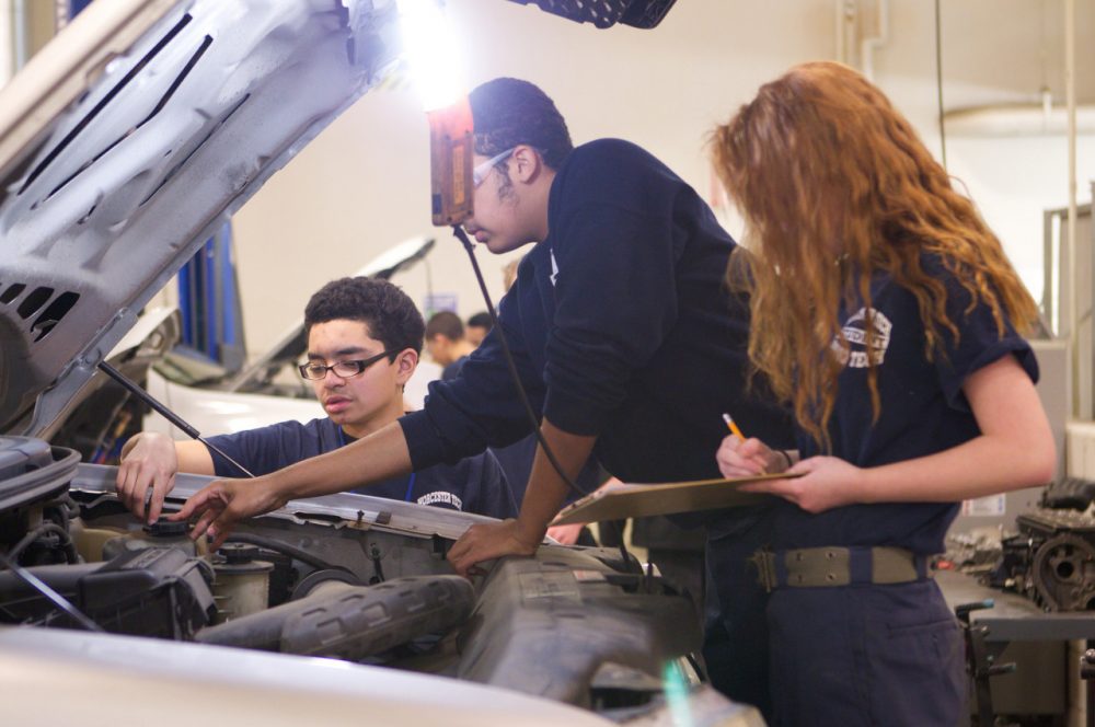 Students work on a car at Worcester Technical High School. (US Department of Education/Flickr)