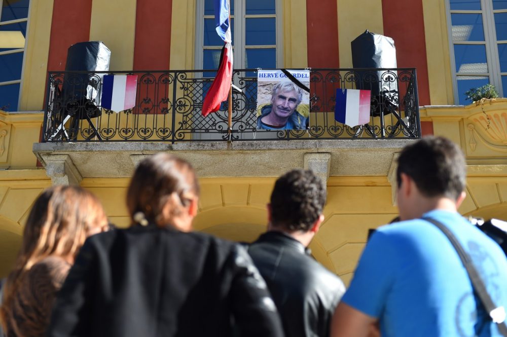 A picture of mountain-guide Herve Gourdel is placed on the town hall's balcony next to the French flag put at half-mast on September 25, 2014, in Saint-Martin-Vésubie, following Gourdel's beheading by Jihadists linked to the Islamic State group in Algeria. )(Anne-Christine Poujoulat/AFP/Getty Images)