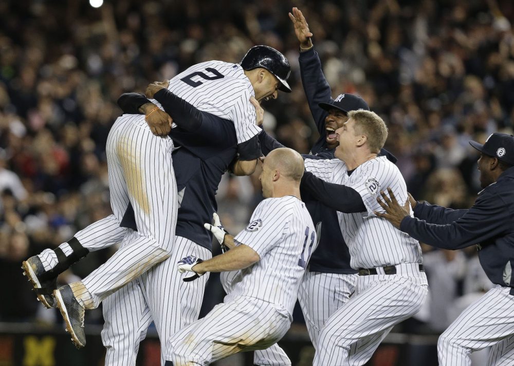 New York Yankees' Derek Jeter (2) is mobbed by teammates after driving in the winning run with a single against the Baltimore Orioles in the ninth inning of a baseball game Thursday. The Yankees won 6-5. (Julie Jacobson/AP)