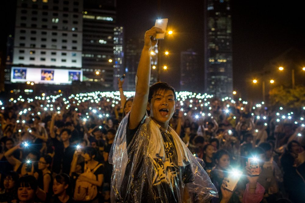 Protesters sing songs and wave their cell phones in the air  outside the Hong Kong Government Complex on September 30, 2014. Thousands of pro democracy supporters continue to occupy the streets surrounding Hong Kong's Financial district despite authorities demanding they withdraw. (Chris McGrath/Getty Images)