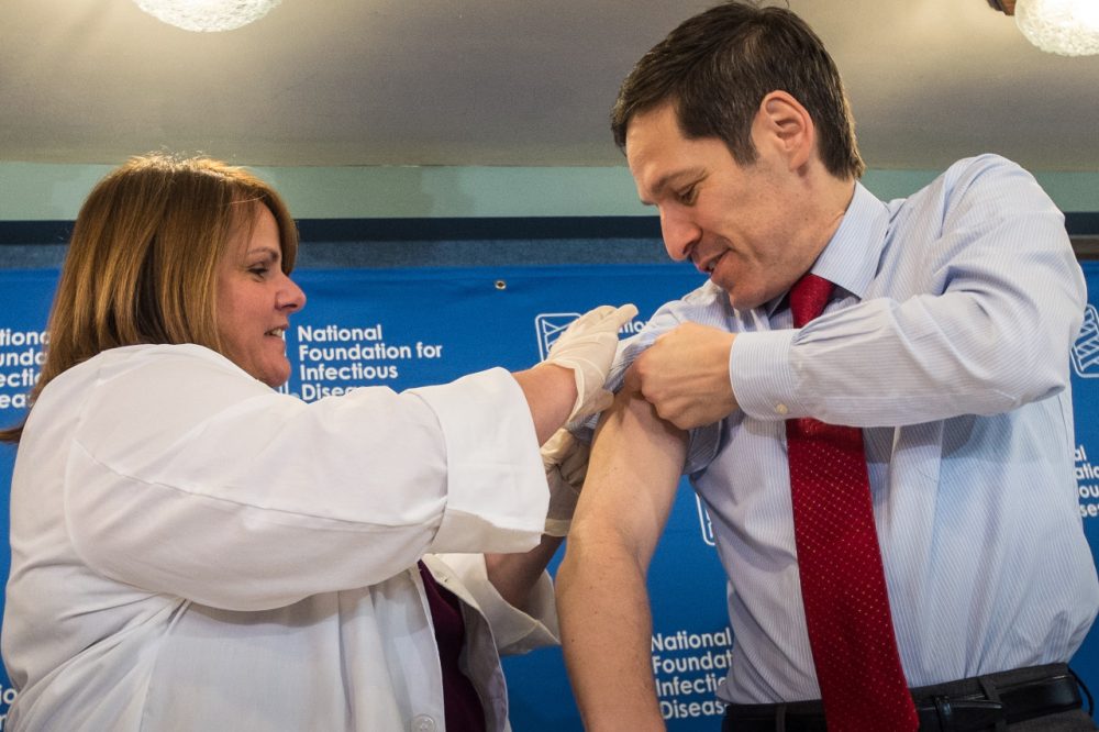 Dr. Thomas Frieden, director of the Centers for Disease Control and Prevention, receives a flu shot from Sharon Bonadies at the conclusion of a news conference at the National Press Club in Washington, Thursday, Sept. 18, 2014.  &quot;Vaccination is the single most important step everyone 6 months of age and older can take to protect themselves and their families against influenza,&quot; said Frieden.  Influenza hospitalized a surprisingly high number of young and middle-aged adults last winter, and this time around the government wants more of them vaccinated. (AP Photo/J. David Ake)