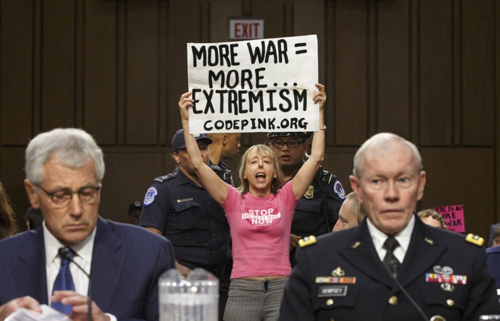 Members of the anti-war activist group CodePink interrupt a Senate Armed Services Committee hearing with Defense Secretary Chuck Hagel, left, and Army Gen. Martin Dempsey, chairman of the Joint Chiefs of Staff, on Capitol Hill in Washington, Tuesday, Sept. 16, 2014. It is the first in a series of high-profile hearings that will measure congressional support for President Barack Obama's strategy to combat Islamic State extremists in Iraq and Syria. (AP)
