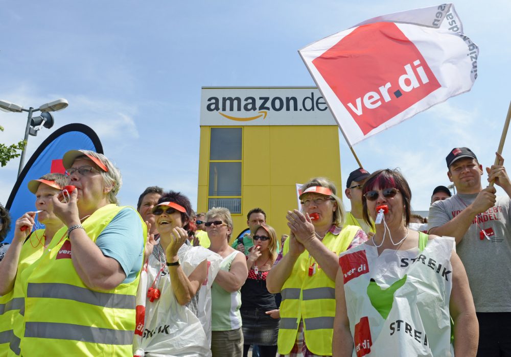 Employees of online retailer Amazon protest during their strike in front of the company's branch in Leipzig, central Germany, Monday, June 17, 2013.  (AP Photo/Jens Meyer)