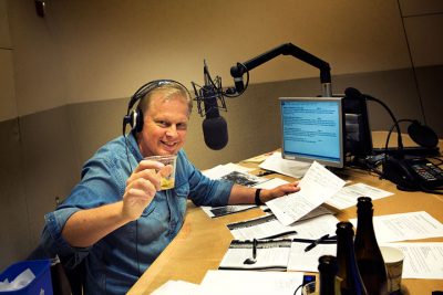 On Point host Tom Ashbrook raises a toast with a glass of fresh apple cider in the On Point studios. (Jesse Costa / WBUR)